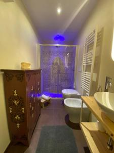 莱切Suite Nina的浴室设有卫生间和带紫色灯的淋浴。