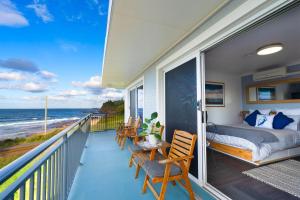 凯阿玛Sea Breeze Studio的一个带一张床和椅子的海景阳台