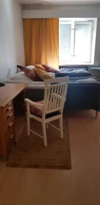 库奥皮奥Veturi B&B的一间卧室配有一张桌子和一张椅子,位于床边