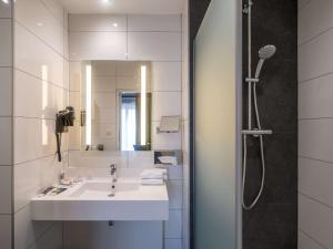 索米尔索米尔卢瓦尔河畔美居酒店的白色的浴室设有水槽和淋浴。