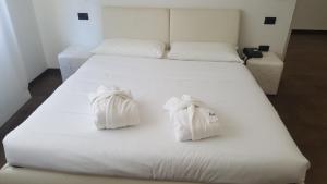 乌迪内克里斯塔罗酒店的一张白色的床,上面有两条白色毛巾