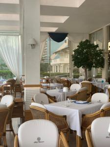 利多迪耶索罗宇宙酒店的餐厅设有白色的桌椅和窗户。