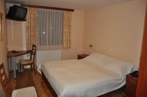 卢布尔雅那克梅茨基赫拉姆旅馆的一间卧室配有一张床、一张桌子和一个窗户。