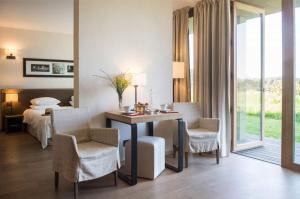 库尔农拉格里兰德斯生态酒店及伊夫黎雪Spa的酒店客房带一张床、一张桌子和椅子