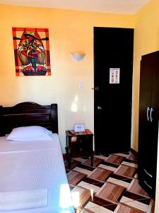 皮乌拉Hotel Calmelia的卧室配有一张床,墙上挂有绘画作品