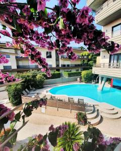 代森扎诺-德尔加达德盛莎诺酒店的一座带游泳池和紫色鲜花的建筑