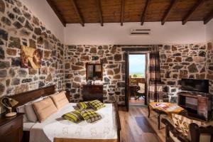 赫索尼索斯巴萨米克传统套房酒店的一间卧室设有一张床和石墙