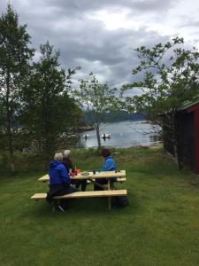 LavikWaerholmen的一群人坐在水边的野餐桌旁