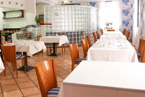马希库安帕罗酒店的用餐室配有桌椅和白色的桌布