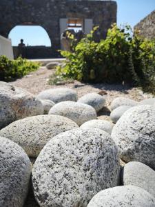 卡拉法蒂斯M-Vibes Mykonos Suites的一堆岩石坐在地上