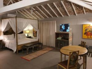 布希奥斯Pedra da Laguna Boutique Hotel SPA的一间卧室配有天蓬床、桌子和桌子。