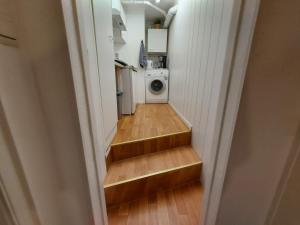科隆Overnight Apartment的走廊设有楼梯,通往带洗衣机的厨房