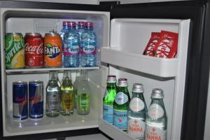 阿克拉The Alima Suites的装满大量苏打水和饮料的开放式冰箱