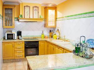 塞维利亚Belvilla by OYO Preciosa casa en Sevilla的厨房设有黄色的墙壁和木制橱柜。