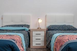 塔拉哈勒赫Casa Yamile的一间卧室配有两张床和一个带灯的床头柜