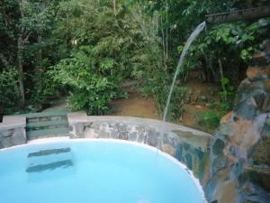 希克杜沃曼塔乐卡巴纳斯山林小屋的一个带瀑布的花园内的热水浴池