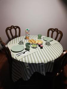 BempostaHouse Diogo的桌子上放有盘子和杯子,上面放有食物
