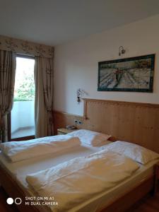 卡瓦雷诺罗萨度假酒店的一间卧室设有一张床,窗户墙上设有地图
