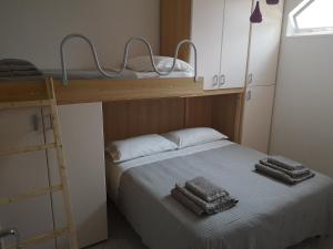 福萨切西亚Il Tetto Verde的一间卧室配有双层床和2条毛巾