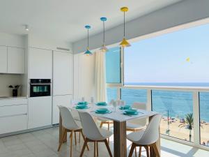 罗列特海岸Seafront New Apartment Boutique的厨房以及带桌椅的用餐室。