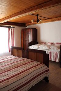 NagyharsányRetro Vendégház的一间卧室设有两张床和木制天花板