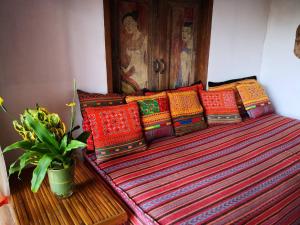 湄斯乐奈富柴塞山度假酒店的一张长凳,上面有色彩缤纷的枕头