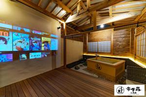 大阪Konjaku-So Shinsaibashi Rooftop SPA的大型客房设有浴缸和电视。