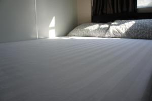 香港宏洋旅店的一间卧室配有一张带白色床罩的床