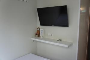 香港宏洋旅店的一间白色墙壁上配有电视的浴室