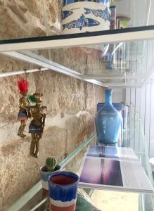卡斯泰拉马莱Calida B&B的玻璃架上装有花瓶和艺术品