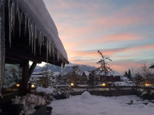 因斯布鲁克格森斯阿尔卑斯艺术酒店的日落时分雪地里冰雪覆盖的房子