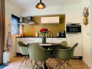 奥特罗Zonnebos, private garden, fresh air, relax!的厨房配有桌椅和花瓶