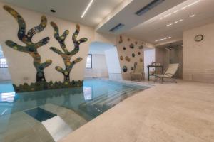 摩德纳迪-坎皮格里奥克里奇奥多洛米蒂酒店的大堂设有墙上树木的游泳池