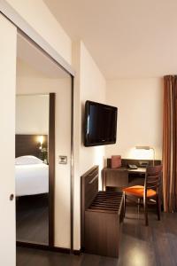 布格奈斯Escale Oceania Nantes Aéroport的配有一张床和一台平面电视的酒店客房
