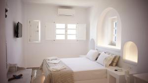 乔拉弗雷恩多斯Paraporti的白色的卧室设有床和窗户