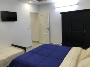 TazarkaMaison de Vacances Tazarka的一间卧室配有蓝色的床和黑色橱柜