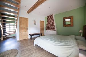 PiennesLes Chambres d'hotes de Sophie的一间设有白色床的卧室,位于一个拥有绿色墙壁的房间