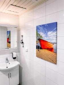 康阿斯阿拉Hotelli Kuohu Kangasala的浴室墙上挂有红色的船画