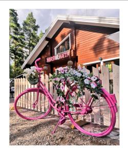鲁奥科拉赫蒂赫尔斯拉昂塔酒店的停在鲜花建筑前面的粉红色自行车