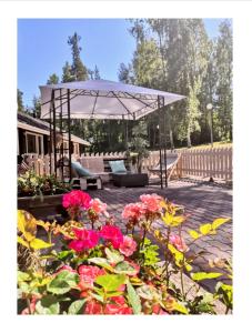 鲁奥科拉赫蒂赫尔斯拉昂塔酒店的一个带白色遮阳伞和一些鲜花的庭院