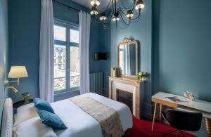 里摩日巴黎酒店的一间拥有蓝色墙壁的卧室和一张带镜子的床