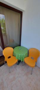普里莫尔斯科Къща за гости ЕЛИ的两把椅子和一张桌子,一张桌子上摆放着绿色和白色的桌子