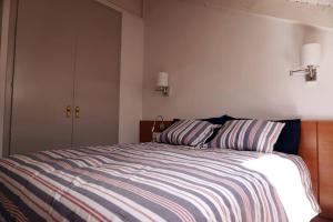 贝纳斯克Ático Pico Cerler的一间卧室配有一张带两个条纹枕头的床