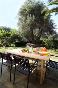 古维亚Villa Rosa Apartments的庭院里配有桌椅和水果