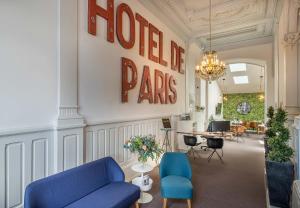 里摩日巴黎酒店的大堂设有两把蓝色椅子,墙上挂着酒店页面标志