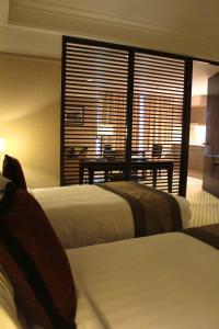 吉隆坡太平洋丽晶套房酒店的酒店客房设有两张床、一张桌子和一个窗户。