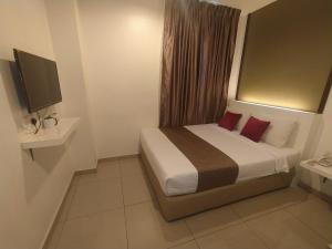 努沙再也Crescendo Boutique Hotel的一间卧室配有一张带红色枕头的床和电视。