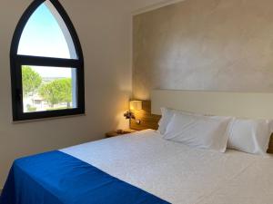 伊索拉迪卡波里祖托La Rustica Hotel的一间卧室设有一张大床和窗户