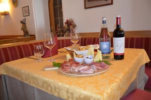 坎皮泰洛迪法萨拉狄那酒店的一张桌子,上面放有两瓶和两杯葡萄酒