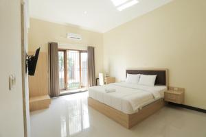 梭罗IDR Green Guest House Syariah Mitra RedDoorz的一间卧室设有一张床和一个大窗户